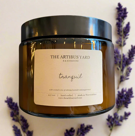 Hand-poured Tranquil soy wax candle by The Artibus Yard, featuring notes of lavender and peppermint; crafted in small batches in Warwickshire and poured into a reusable amber glass jar.