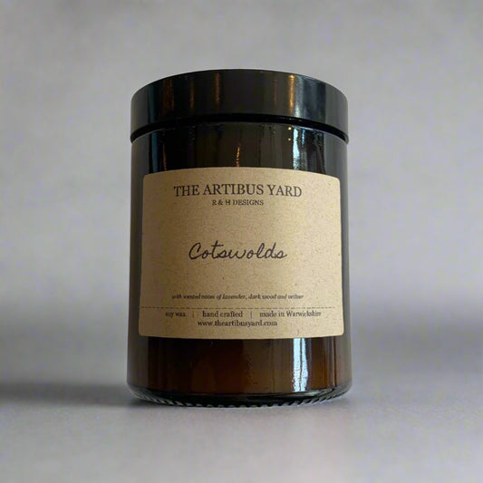 Hand-poured Cotswolds soy wax candle by The Artibus Yard, featuring notes of lavender, dark wood and vetiver; crafted in small batches in Warwickshire and poured into a reusable amber glass jar.