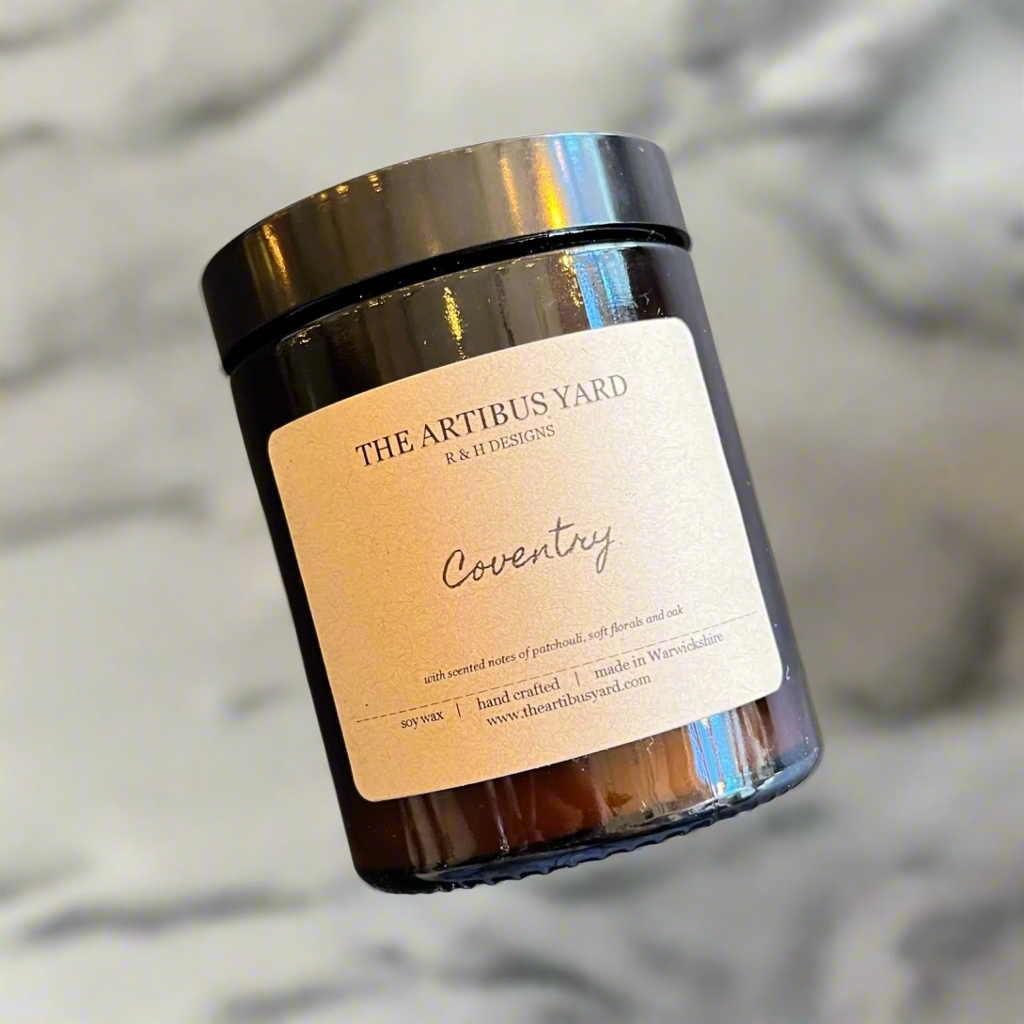 Hand-poured Coventry soy wax candle by The Artibus Yard, featuring notes of patchouli, soft florals and oak; crafted in small batches in Warwickshire and poured into a reusable amber glass jar.