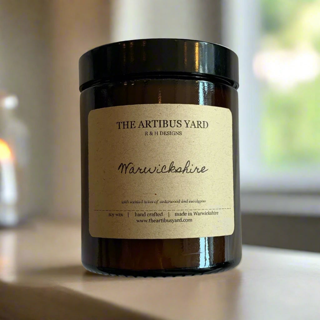 Hand-poured Warwickshire soy wax candle by The Artibus Yard, featuring notes of cedarwood and eucalyptus; crafted in small batches in Warwickshire and poured into a reusable amber glass jar.
