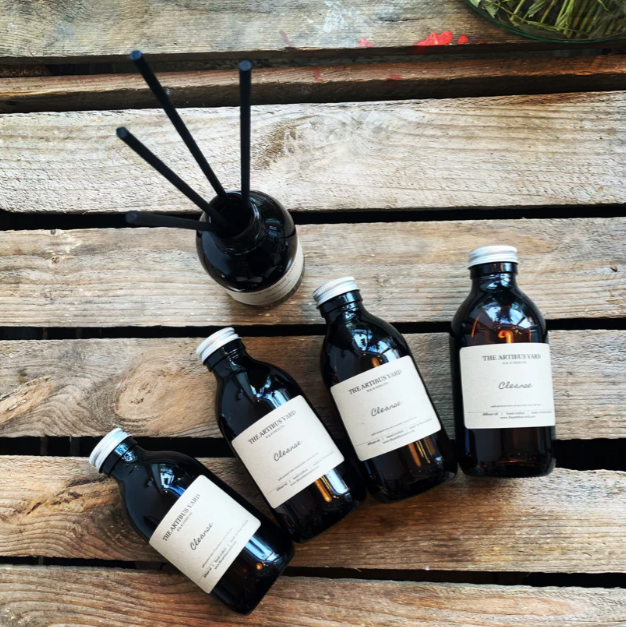 Castle Gardens reed diffuser by The Artibus Yard, with vine leaves, oregano and lemon notes, housed in an amber glass bottle with black reed sticks for long-lasting fragrance.