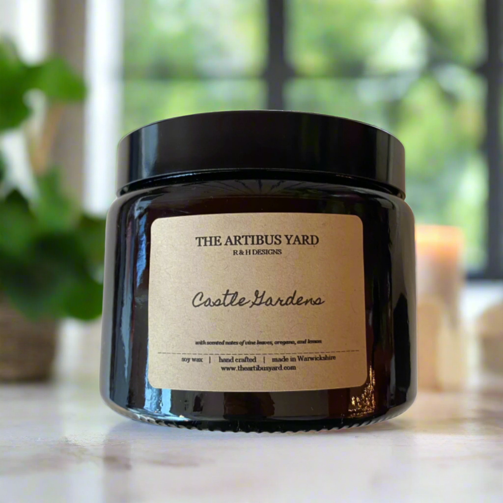 Hand-poured Castle Gardens soy wax candle by The Artibus Yard, featuring notes of vine leaves, oregano, and lemon; crafted in small batches in Warwickshire and poured into a reusable amber glass jar.
