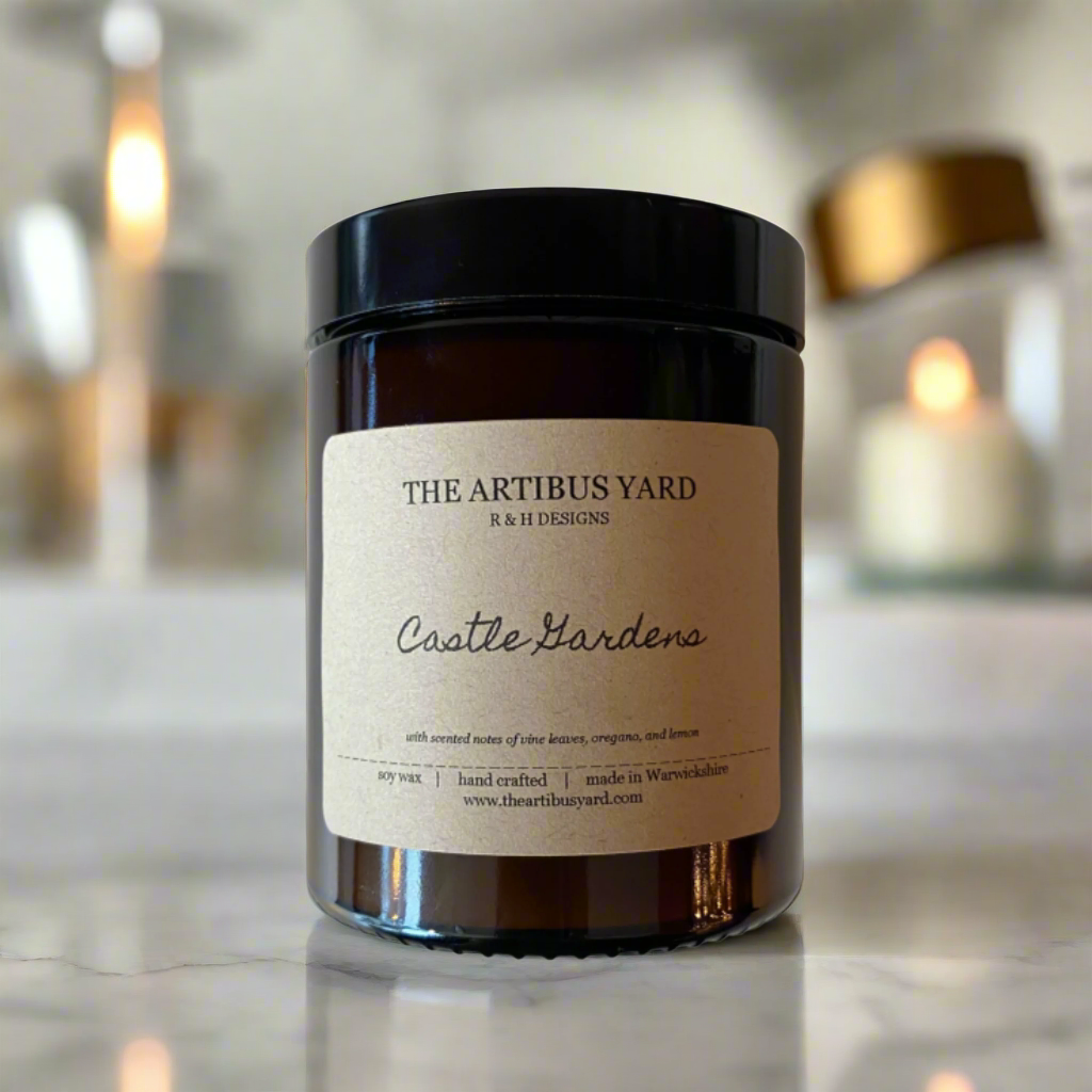 Hand-poured Castle Gardens soy wax candle by The Artibus Yard, featuring notes of vine leaves, oregano, and lemon; crafted in small batches in Warwickshire and poured into a reusable amber glass jar.