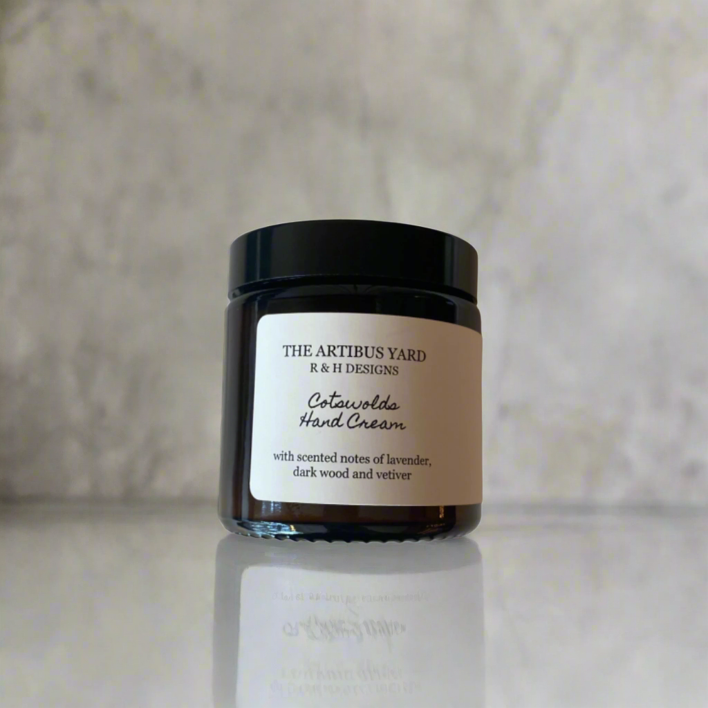 Cotswolds scented hand cream by The Artibus Yard, enriched with nourishing ingredients and warm and woody notes, packaged in an amber glass bottle.
