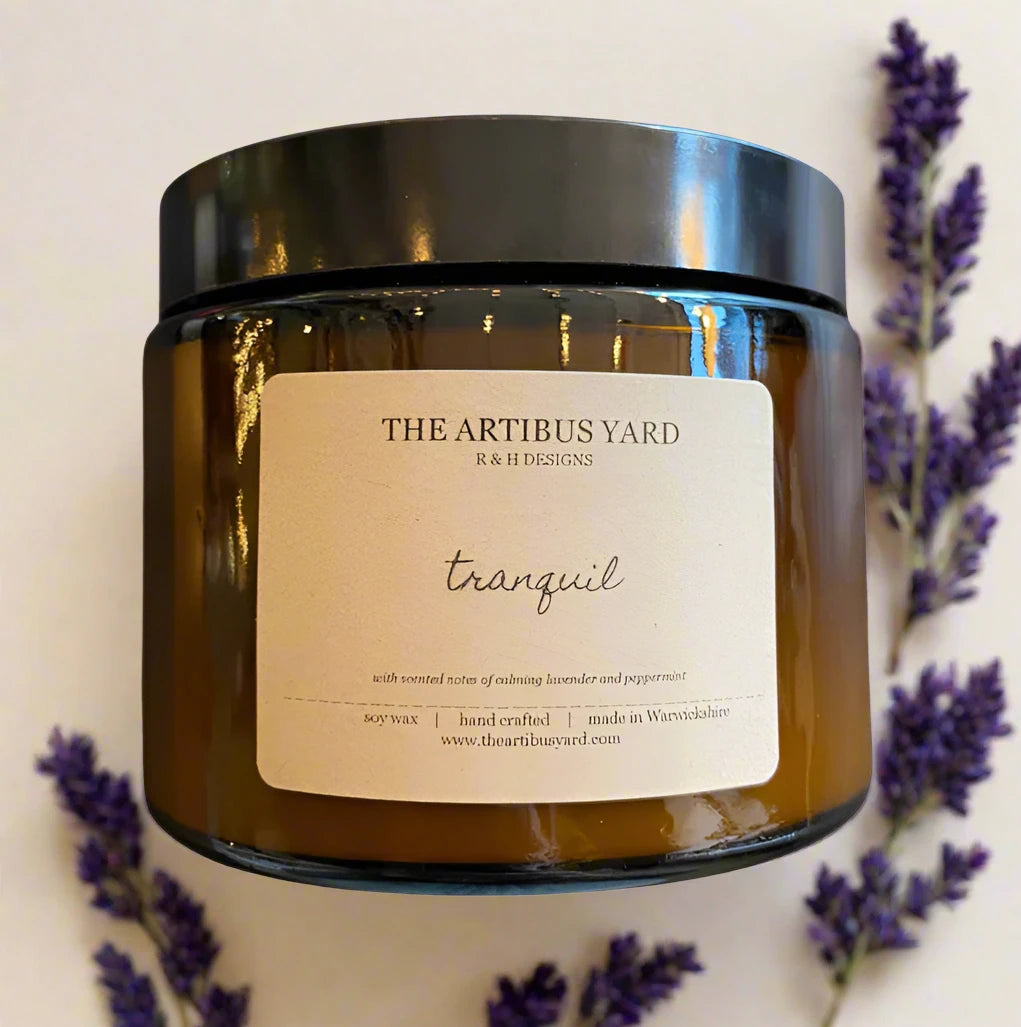 Hand-poured Tranquil soy wax candle by The Artibus Yard, featuring notes of lavender and peppermint; crafted in small batches in Warwickshire and poured into a reusable amber glass jar.