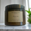 Hand-poured Warwick soy wax candle by The Artibus Yard, featuring notes of cedar, vetiver and patchouli; crafted in small batches in Warwickshire and poured into a reusable amber glass jar.