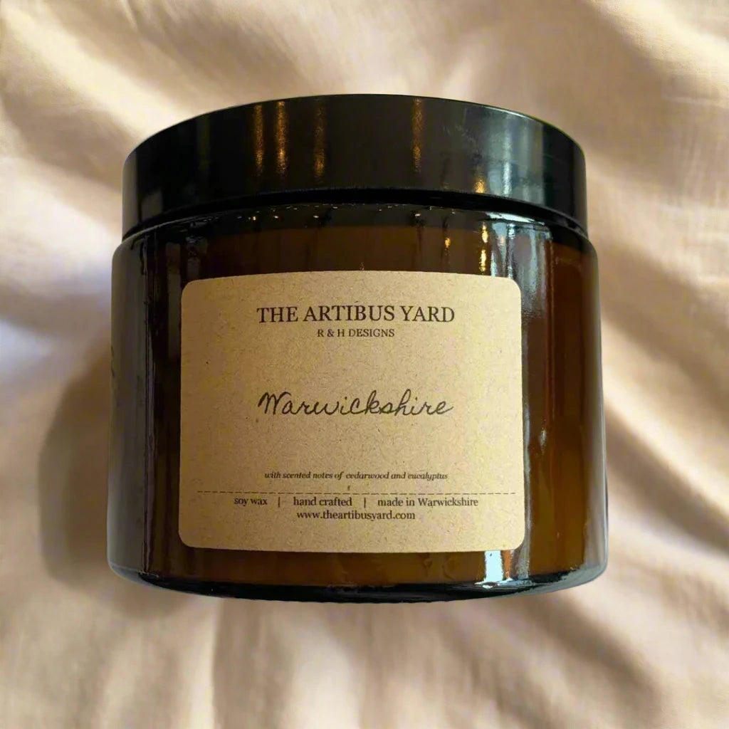 Hand-poured Warwickshire soy wax candle by The Artibus Yard, featuring notes of cedarwood and eucalyptus; crafted in small batches in Warwickshire and poured into a reusable amber glass jar.