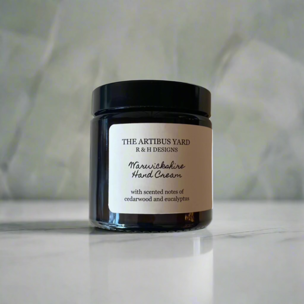 Warwickshire scented hand cream by The Artibus Yard, enriched with nourishing ingredients and fresh and woody notes, packaged in an amber glass bottle 