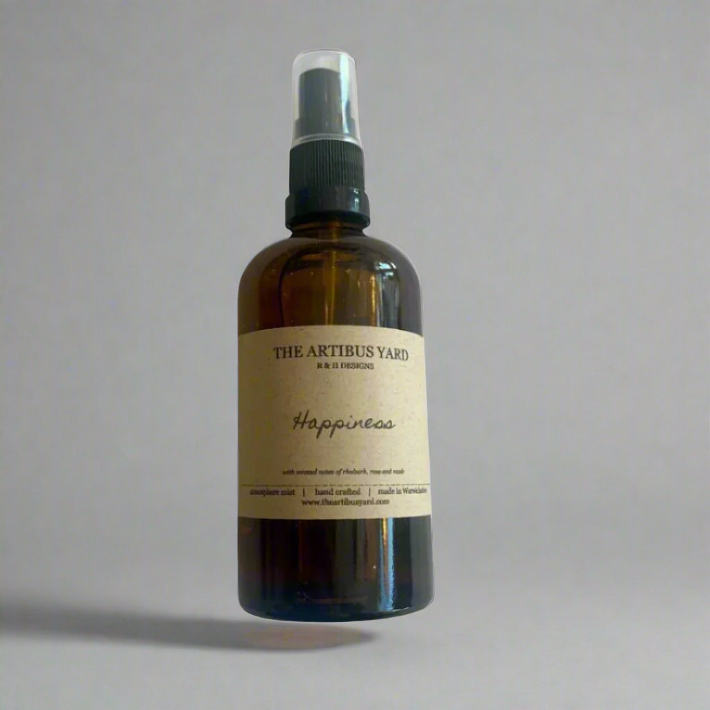 Happiness atmosphere mist by The Artibus Yard, featuring rhubarb, rose and musk notes in a sleek spray bottle.