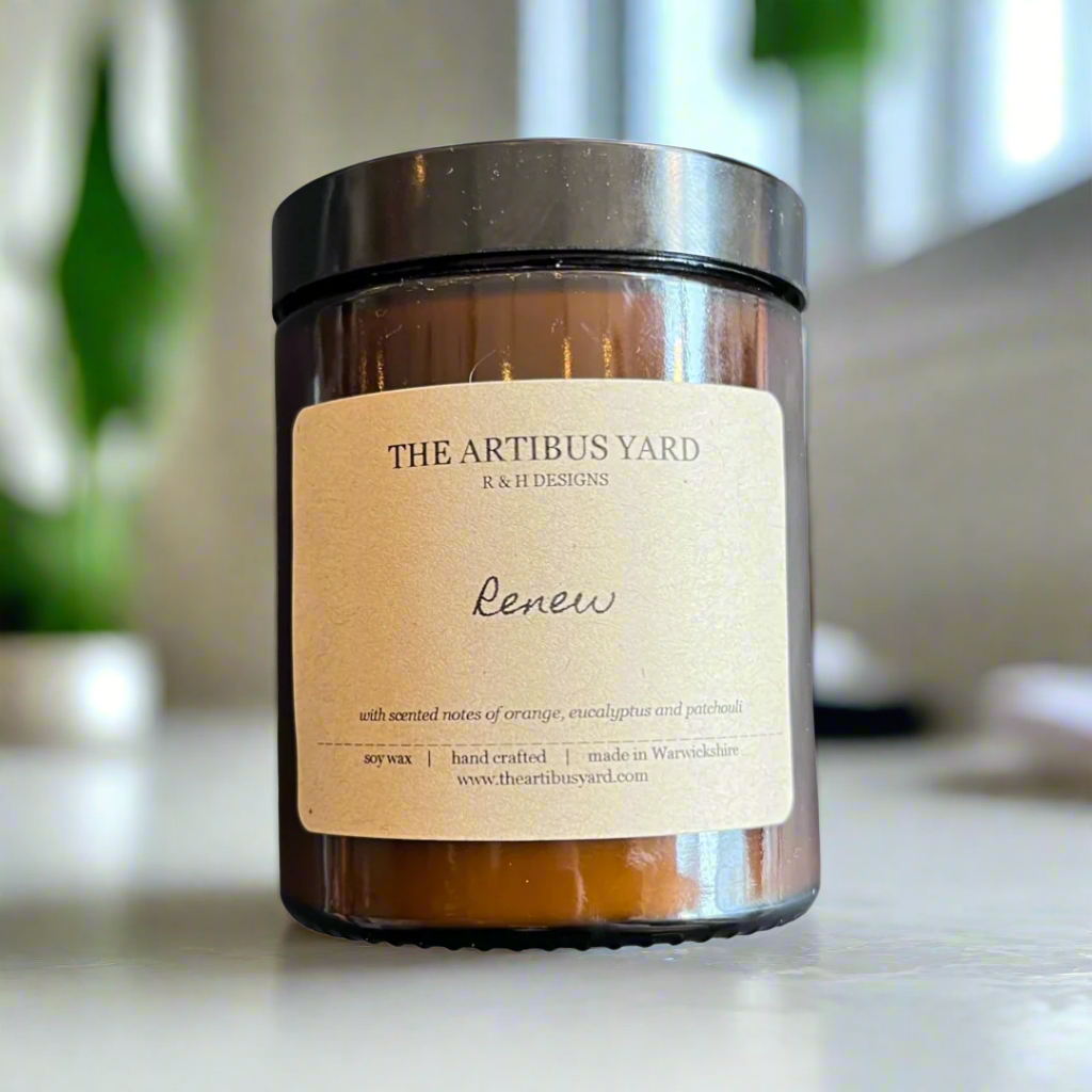 Hand-poured Renew soy wax candle by The Artibus Yard, featuring notes of orange, patchouli and eucalyptus; crafted in small batches in Warwickshire and poured into a reusable amber glass jar.