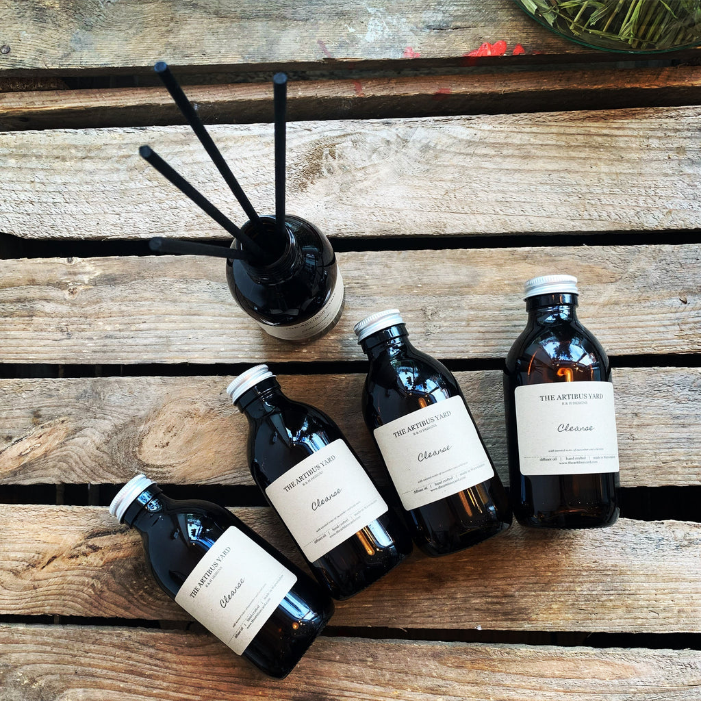 Tranquil reed diffuser by The Artibus Yard, with lavender and peppermint, housed in an amber glass bottle with black reed sticks for long-lasting fragrance.